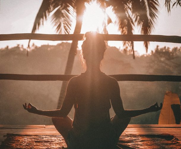 woman doing yoga meditation on brown parquet flooring